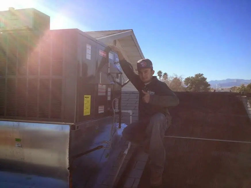 HVAC technician performing Air Duct Cleaning on a rooftop unit in Hurley
